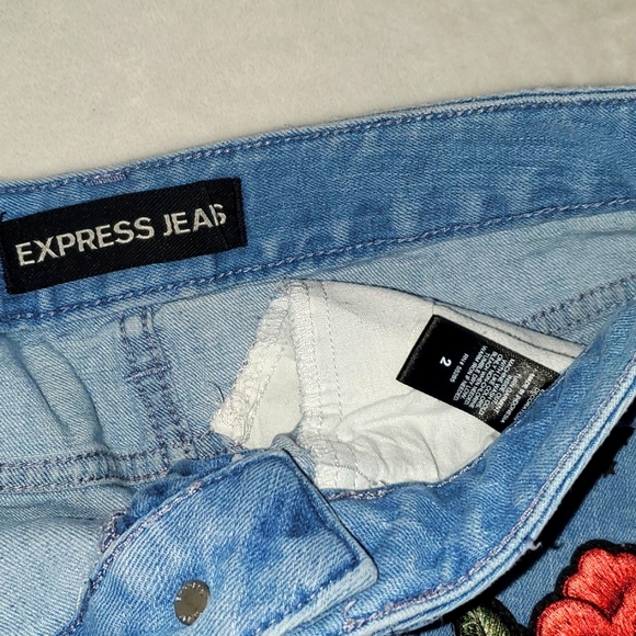 Express Distressed Raw Hem Rose Accent Blue Denim Shorts - Picture 2 of 3